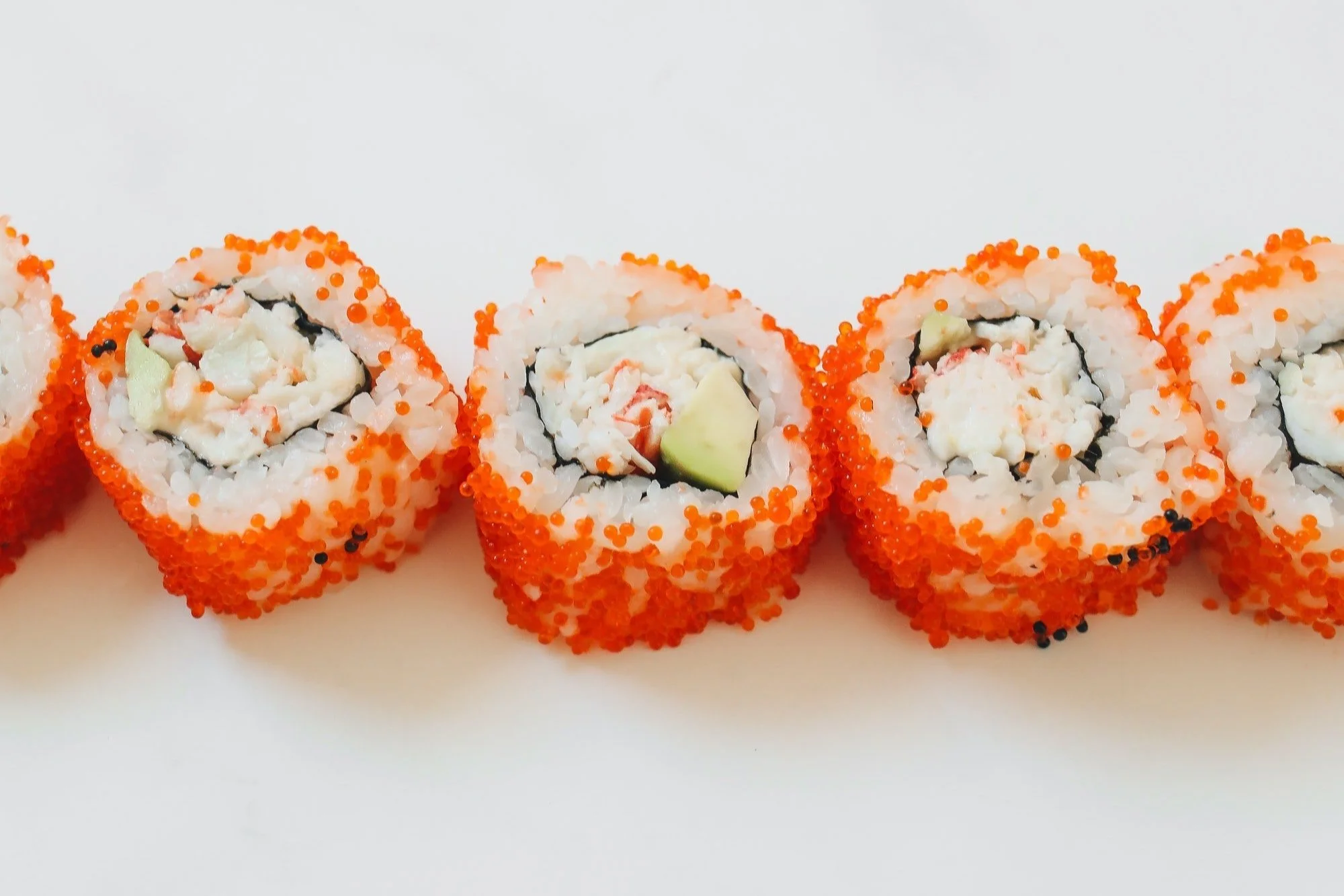 California roll topped with tobiko roe prepared for a New York City sushi catering event