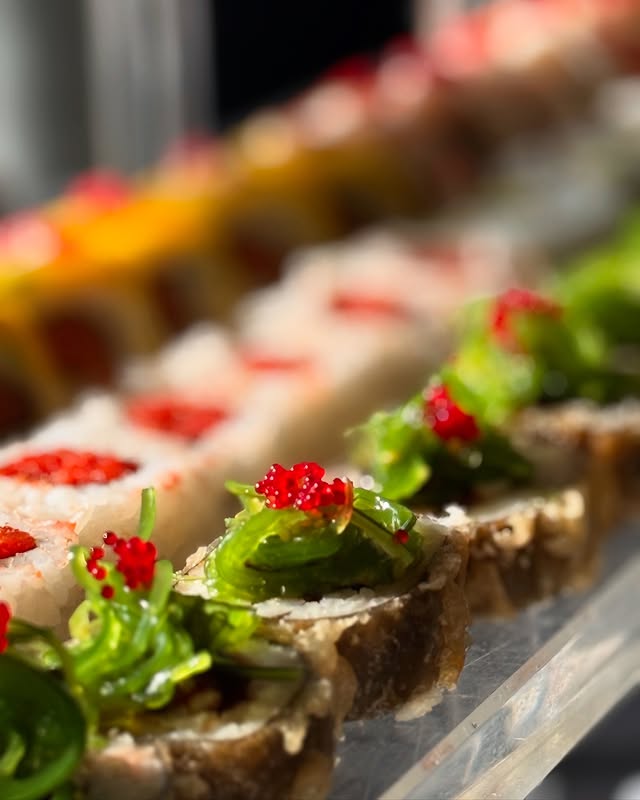Sushi rolls with vibrant tobiko garnish arranged for a catering display in New York City